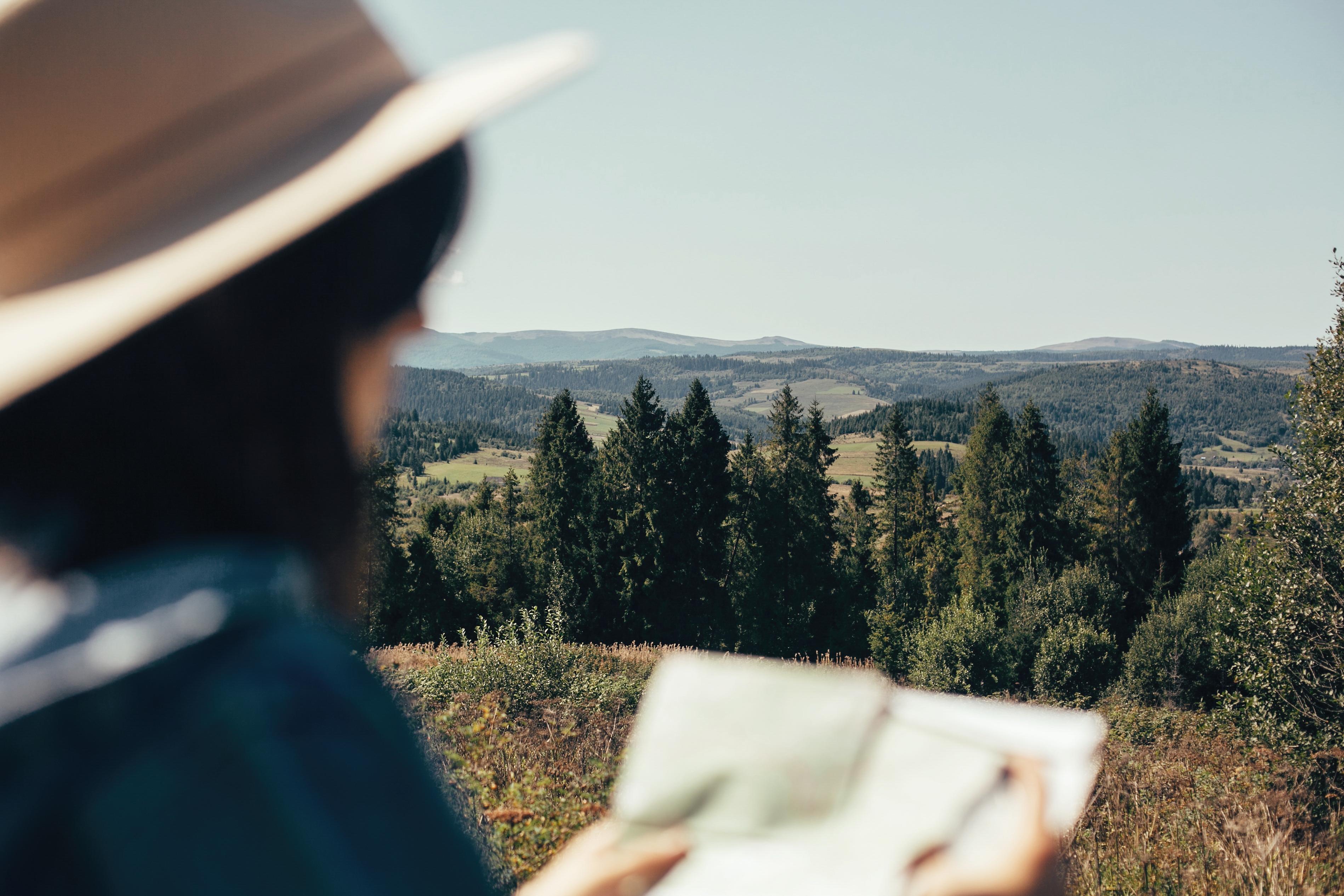 Femme lisant une feuille devant un paysage